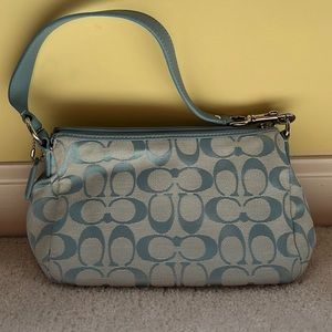 Small light blue Coach purse with monogram print.